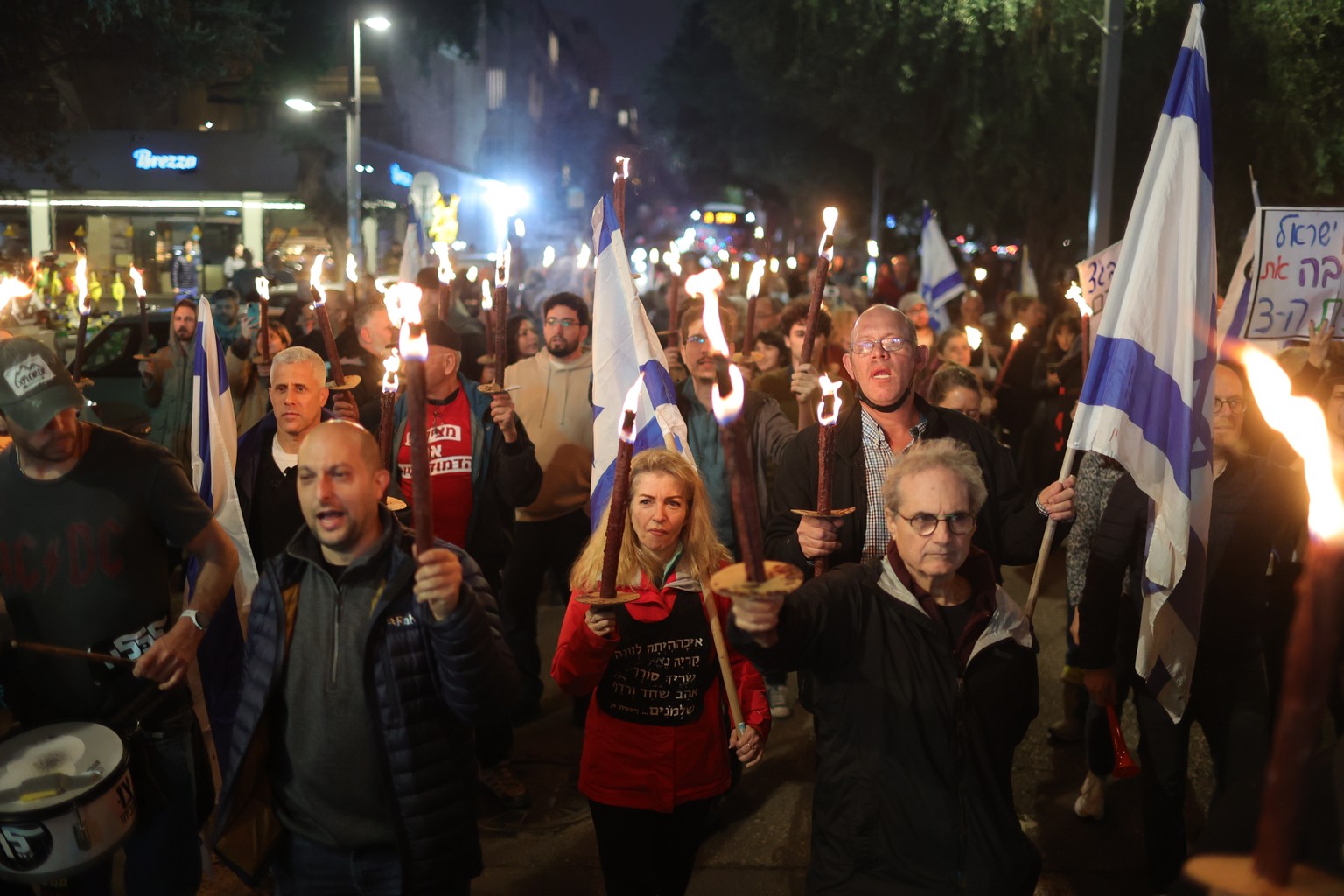 epa10394628 Israeli protesters light torches as they take part in a protest march against the new government in Tel Aviv, Israel, 07 January 2023. A statement made by the new minister of justice Yariv ...