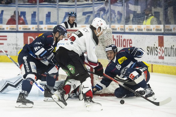 Lausanne&#039;s player Ken Jaeger, center, fights for the puck with Ambri&#039;s player Rocco Pezzullo, right, during the regular season National League match between HC Ambri Piotta and Lausanne HC,  ...