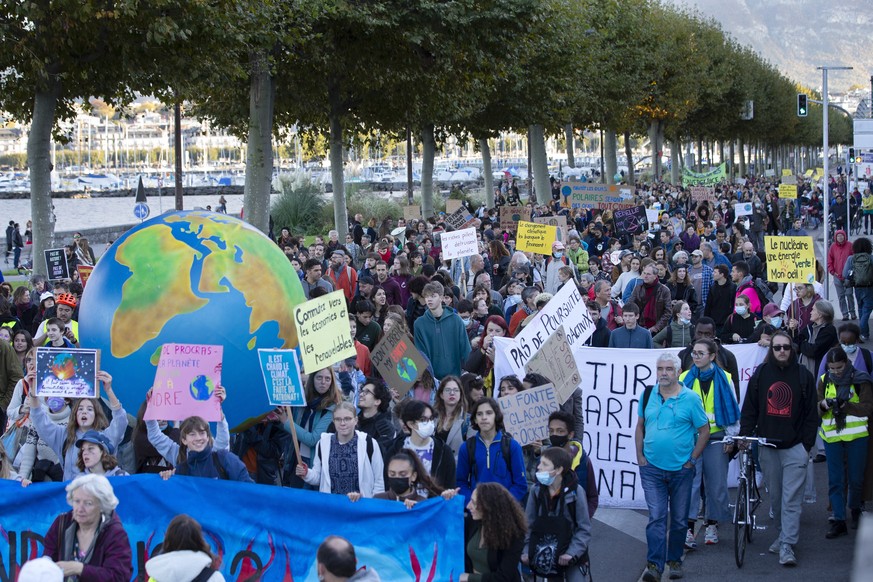 epa09539414 People holding placards attend a Global Climate Strike demonstration during the international strike day of Fridays For Future, in Geneva, Switzerland, 22 October 2021. Global Climate Stri ...