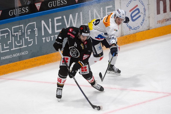 Lugano&#039;s player Joey LaLeggia, left, fights for the puck with Ambri&#039;s player Jakob Lilija, right, during the preliminary round game of National League Swiss Championship 2023/24 between HC L ...