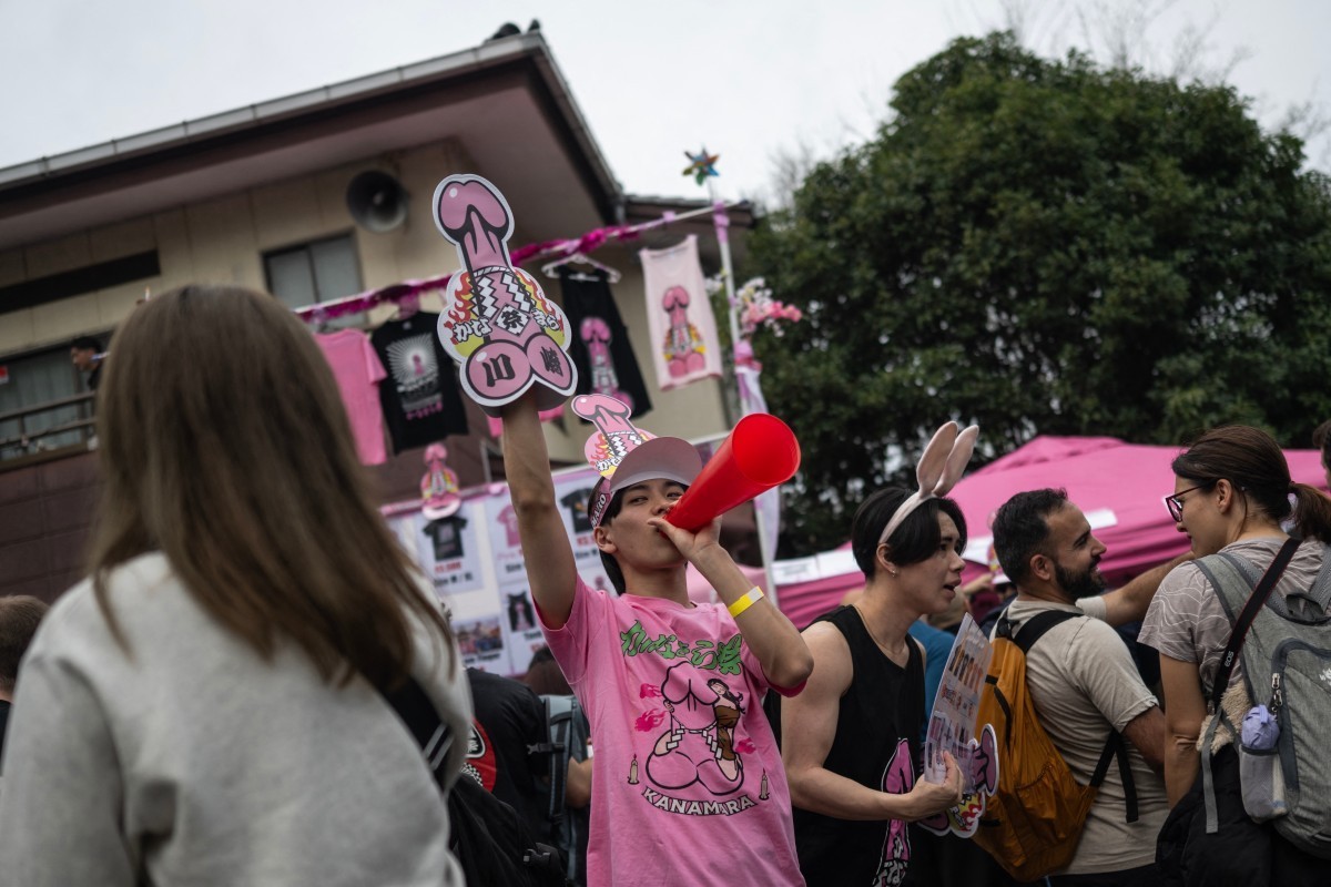 A vendor calls for people's attention as he sells phallic hats during the Kanamara festival at the Kanayama Shrine in Kawasaki on April 5, 2026. Showcasing phallus-shaped portable shrines and pin ...