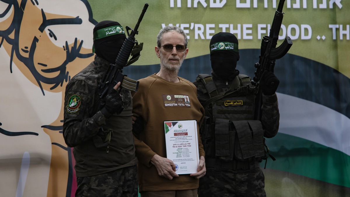 epaselect epa11882145 Palestinian fighters from Hamas's Izz ad-Din al-Qassam Brigades escort Israeli hostages Ohad Ben-Ami (pictured), Or Levi and Eli Sharabi onto the stage before handing them o ...
