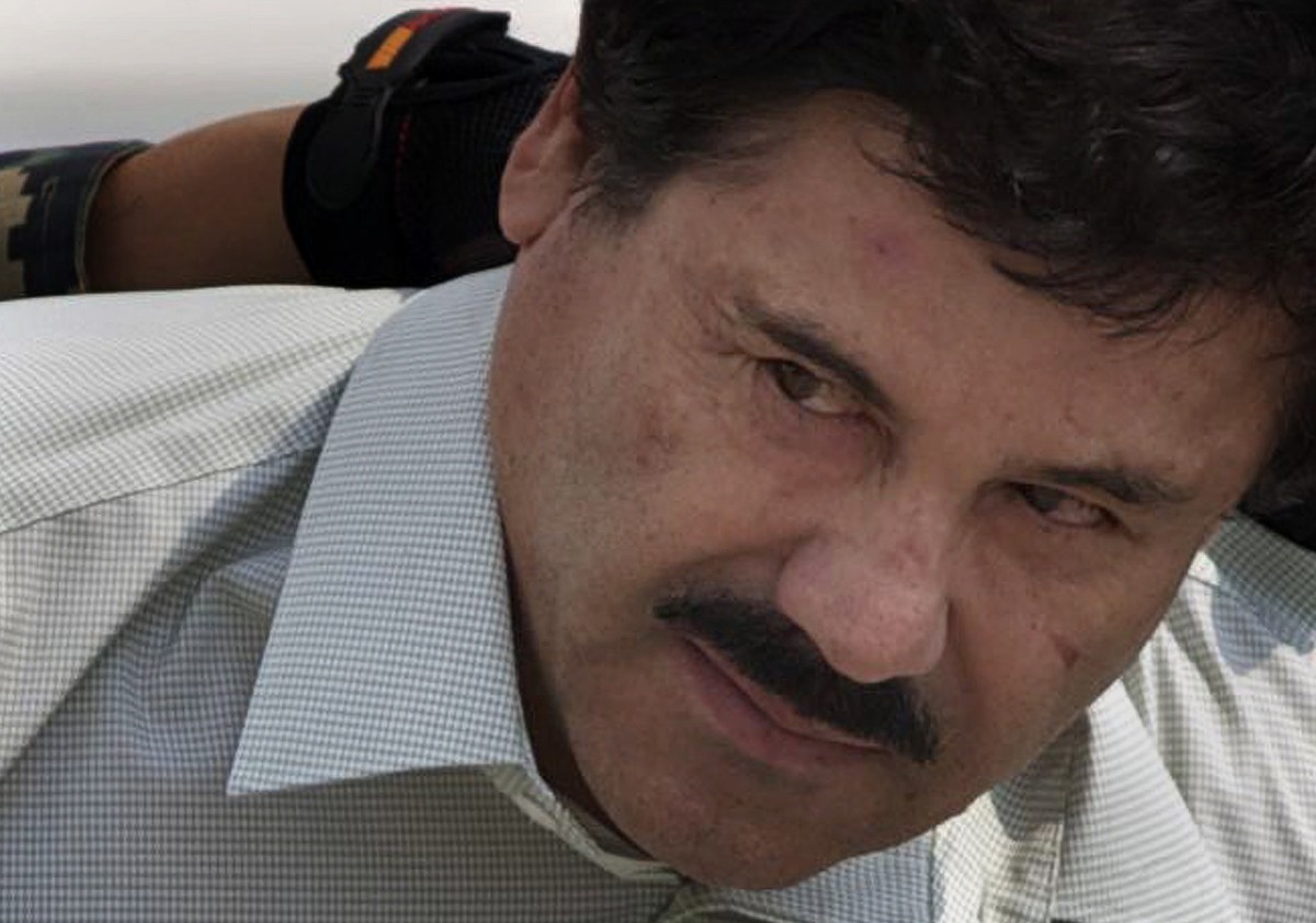 FILE - In this Feb. 22, 2014 file photo, Joaquin "El Chapo" Guzman is escorted to a helicopter in handcuffs by Mexican navy marines at a navy hanger in Mexico City. According to Mexico' ...