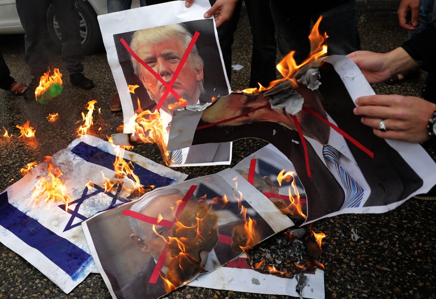 epa06371705 Palestinians burn Israeli and US flags and posters of US President Donald Trump and Israeli Prime Minister Benjamin Netanyahu during protest against the US intention to move its embassy to ...