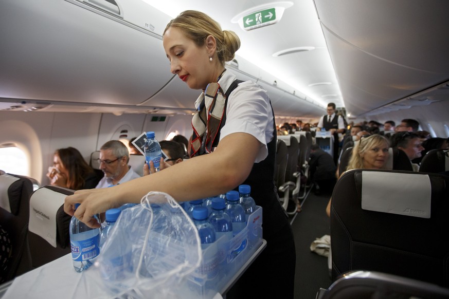 Flight attendants, of Swiss International Air Lines, serve passengers on board of Bombardier CS300 aircraft from Swiss International Air Lines, during an official inauguration in Geneva, Switzerland,  ...