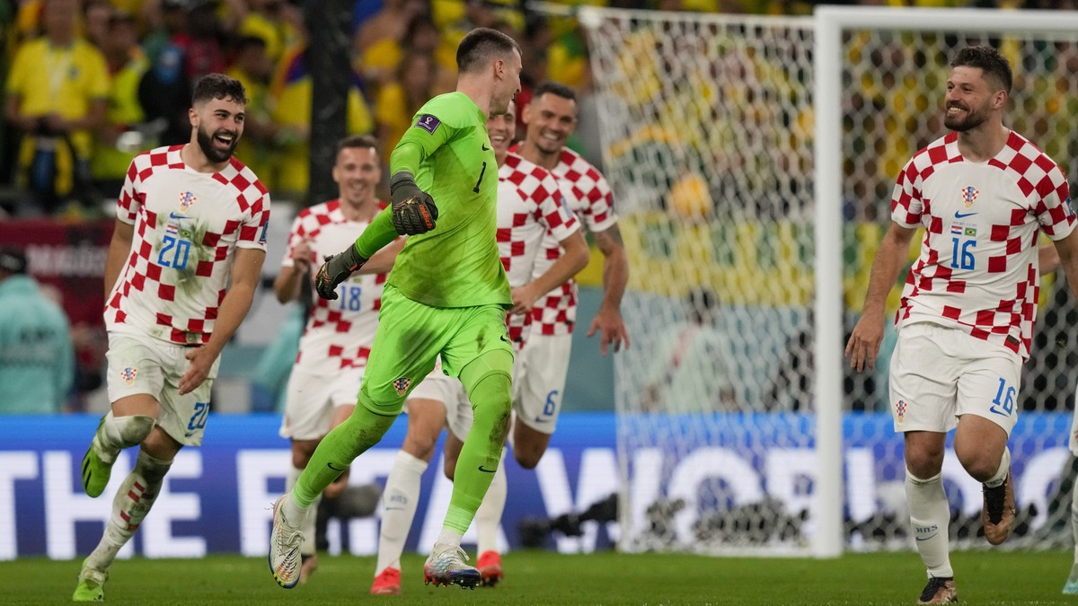 Croatia's goalkeeper Dominik Livakovic celebrates with teammates after the last penalty by Brazil's Marquinhos was hit the post during penalties shootout the World Cup quarterfinal soccer ma ...