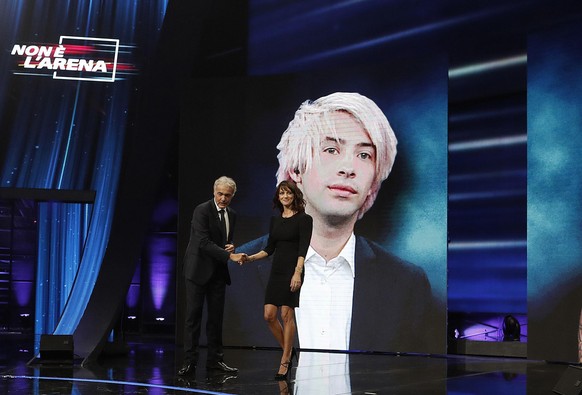 Italian actress Asia Argento is welcomed by TV host Massimo Gilletti, left, as a picture of US actor Jimmy Bennett is seen in background, during the Italian TV LA7 program &quot; Non e&#039; l&#039;Ar ...