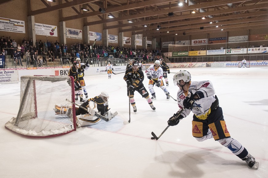 Wikis Goalie Lars Lenze, und Noel Waber, Mitte, werden umkurvt von Zugs Raphael Diaz, rechts, im Swiss Ice Hockey Cup zwischen dem EHC Wiki-Muensingen aus der ersten Liga und dem EV Zug, am Dienstag,  ...