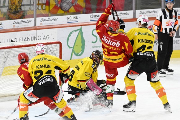Tigers Flavio Schmutz, Mitte, im Kampf um den Puck gegen Berns Goalie Adam Reidebor, links, und Simon Kindschi, rechts, beim Eishockey-Qualifikationsspiel der National League, zwischen den SCL Tigers  ...