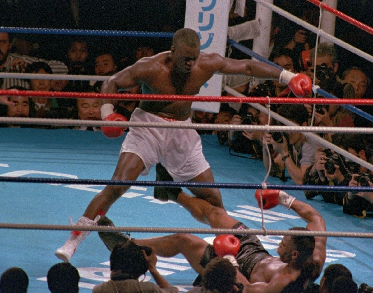 FILE - In this Sunday, Feb. 11, 1990 file photo, James "Buster" Douglas, stands over Mike Tyson who fell on his back after taking a series of blows in the 10th round of their world heavyweig ...