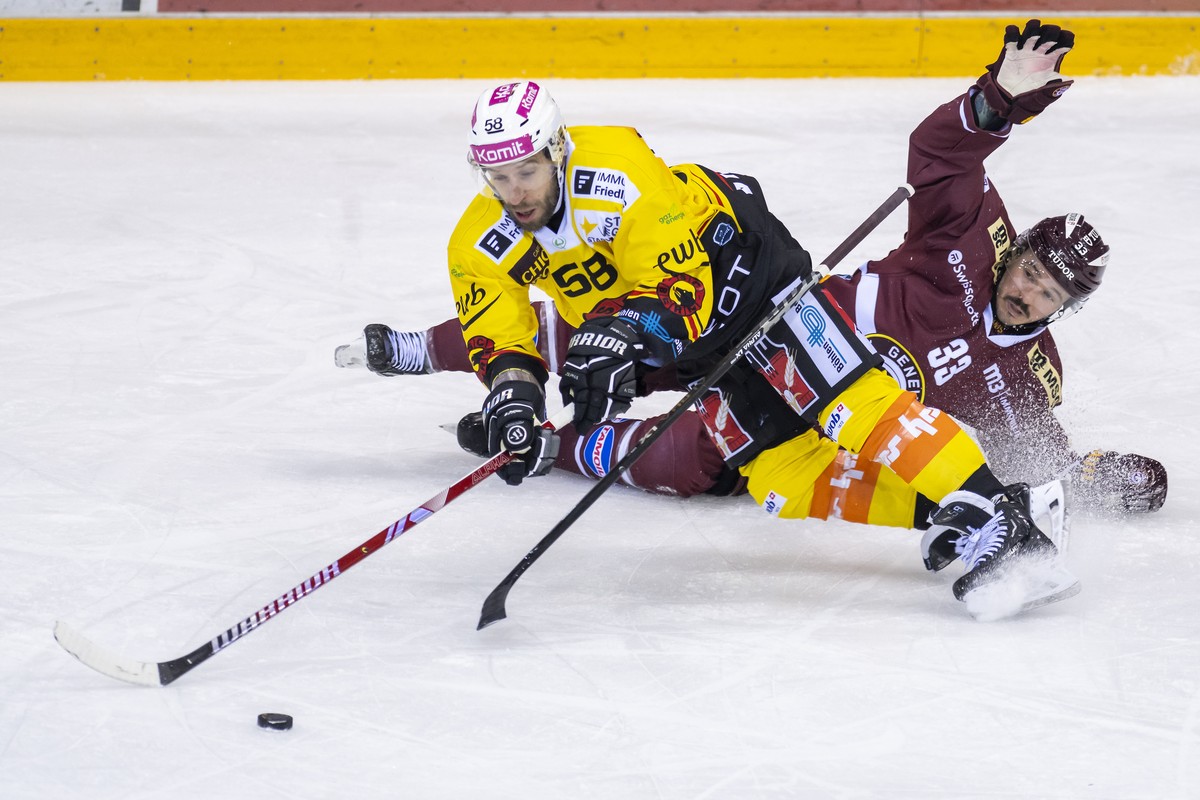 Le defenseur bernois Romain Loeffel, gauche, a la lutte pour le puck avec l'attaquant genevois Alessio Bertaggia, droite, lors du match du championnat suisse de hockey sur glace de National Leagu ...