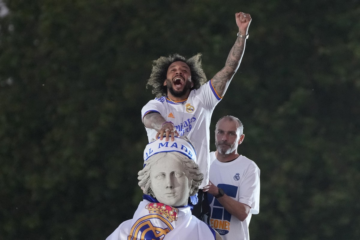 Real Madrid's Captain Marcelo celebrates on top of the Cibeles goddess statue after Real Madrid won the Spanish La Liga title after defeating Espanyol in Madrid, Spain, Saturday, April 30, 2022.  ...