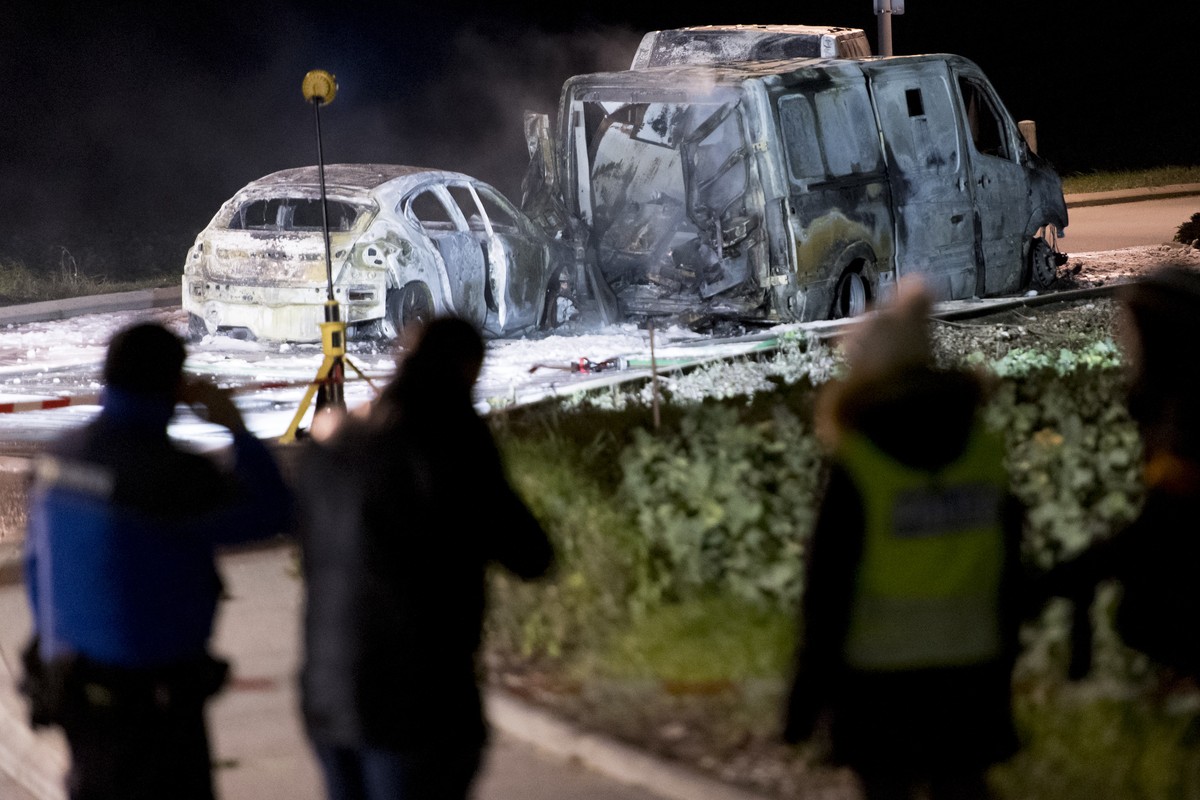 Des policiers photographies trois vehicules calcines a la sortie du village apres l'attaque d'un fourgon de transport de fonds ce lundi 2 decembre 2019 a Daillens. (KEYSTONE/Laurent Gilliero ...