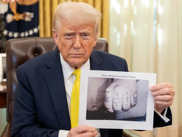 Trump hält ein Foto von einem vermeintlichen Gang-Tattoo des nach El Salvador deportierten Kilmar Abrego Garcia.