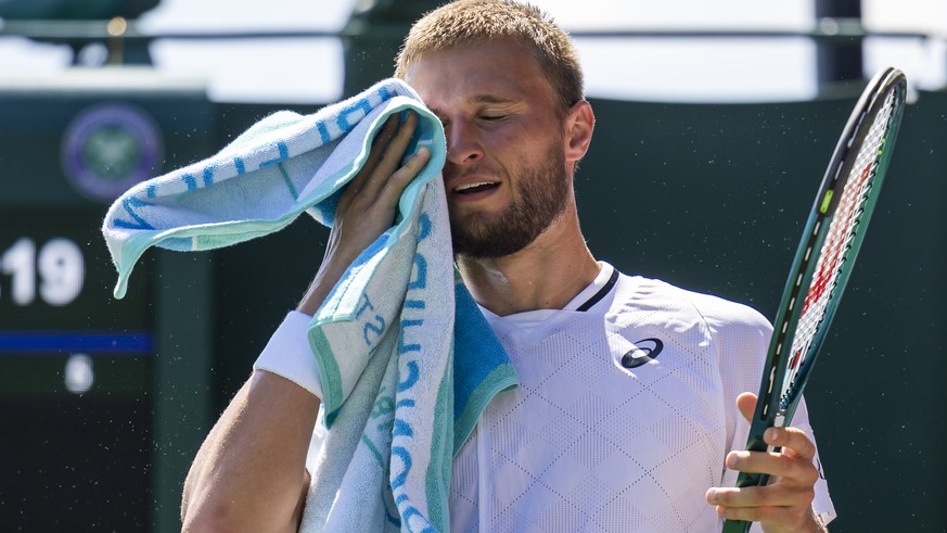 Leandro Riedi of Switzerland wipes his face during his first round match against Oliver Tarvet of Great Britain at the All England Lawn Tennis Championships in Wimbledon, London, Monday, June 30, 2025 ...