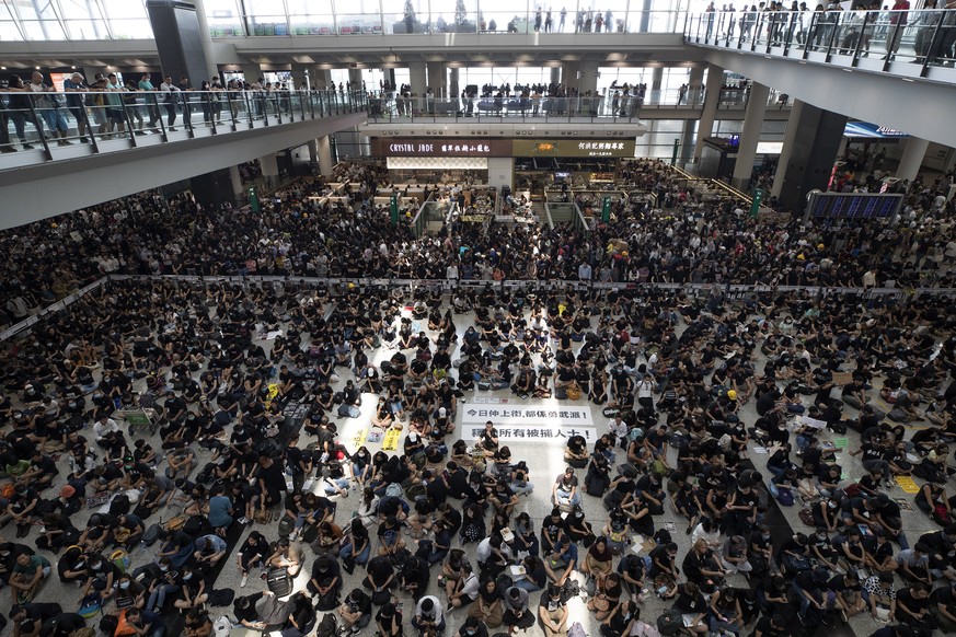 THIS ADDS TO CLARIFY THE TRANSLATION - Protesters surround banners that read: &quot;Those on the street today are all warriors!&quot; center top, and &quot;Release all the detainees!&quot; during a si ...