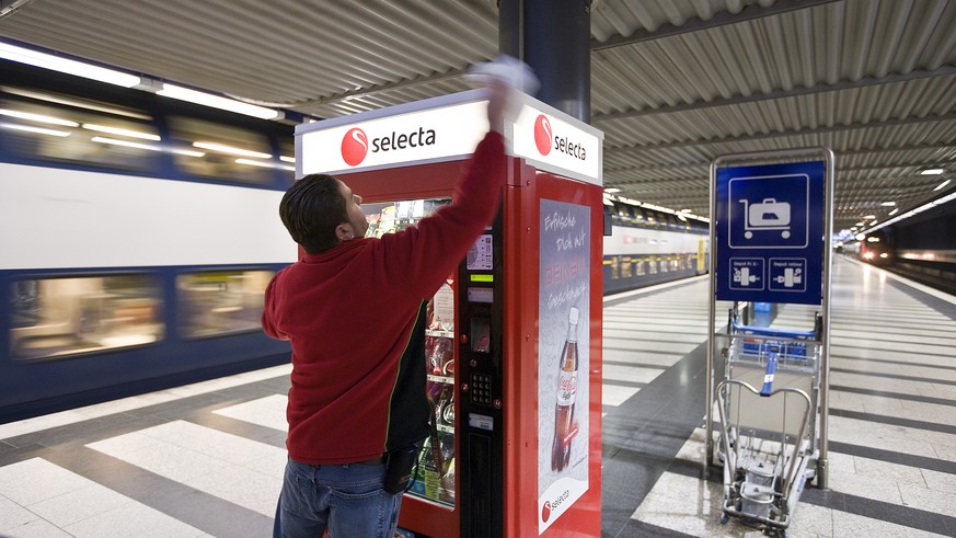 An employee of Selecta cleans a Selecta snack vending machine in the underground part of the main train station in Zurich, Switzerland, pictured on January 20, 2009. (KEYSTONE/Gaetan Bally)

Ein Mitar ...