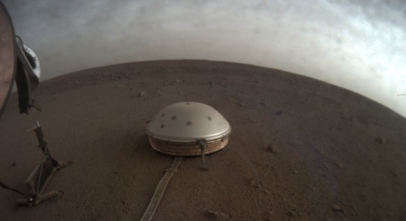 In this undated photo made available by NASA on Thursday, July 22, 2021, clouds drift over the dome-covered SEIS seismometer of the InSight lander on the surface of Mars. The quake-measuring device is ...