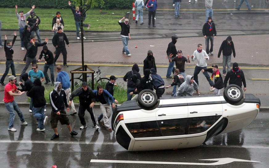 Randalierende Hooligans kippen ein ziviles Polizeifahrzeug nach dem Fussball Meisterschaftsspiel der Super League zwischen dem FC Basel und dem FC Zuerich am Samstag, 13. Mai 2006, in Basel. (KEYSTONE ...