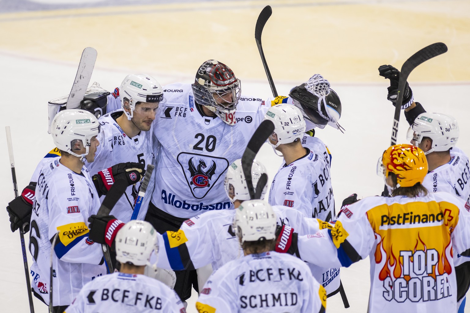 Le gardien du fribourg Reto Berra, centre, laissent eclater sa joie avec ces coequipiers, lors du match du championnat suisse de hockey sur glace de National League LNA, entre le Geneve Servette HC et ...