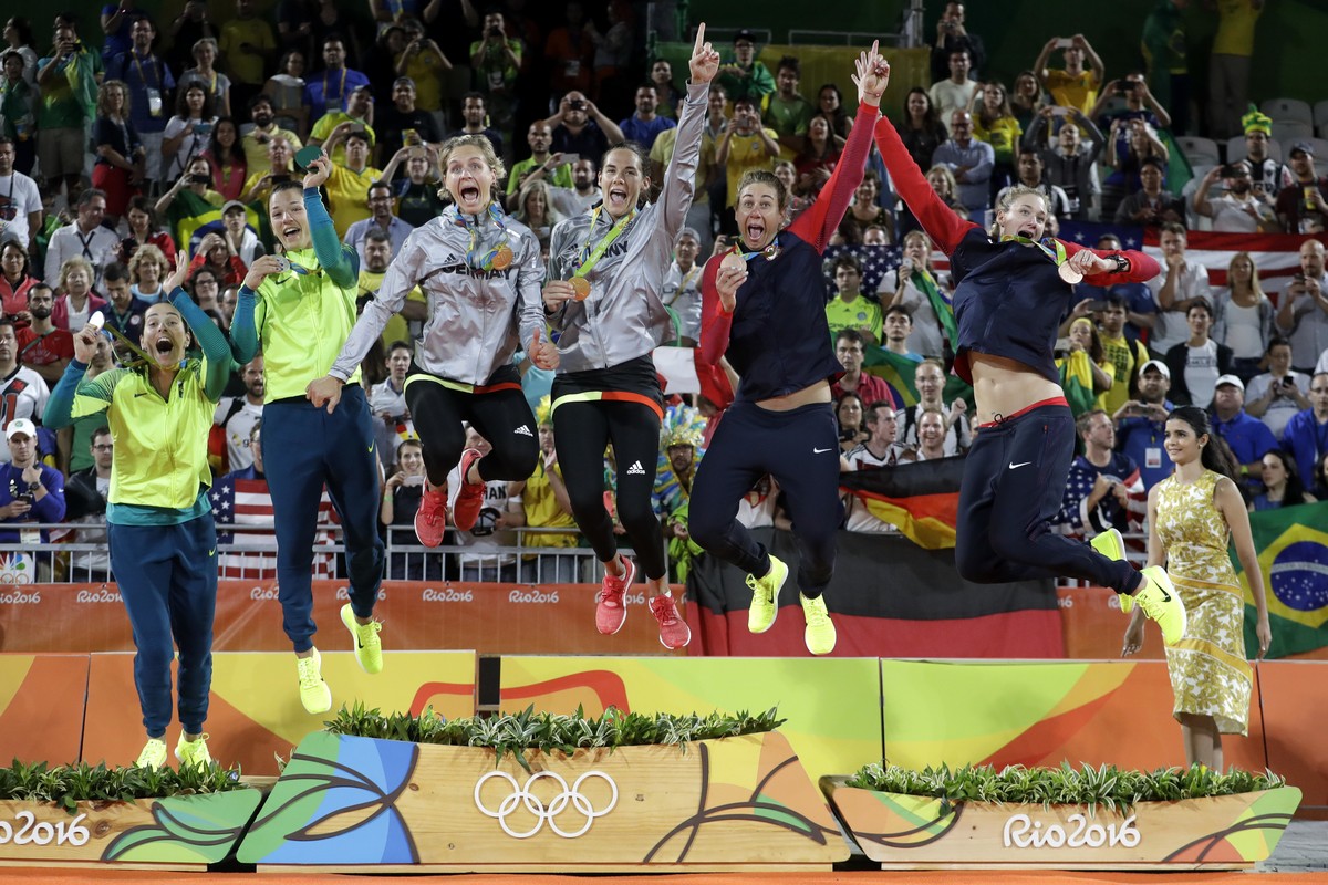 Medalists jump off the podium after the medals ceremony in the women's beach volleyball competion of the 2016 Summer Olympics in Rio de Janeiro, Brazil, Thursday, Aug. 18, 2016. From left are, Br ...