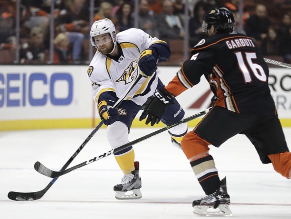 Nashville Predators&#039; Yannick Weber, left, of Switzerland, passes the puck as he is defended by Anaheim Ducks&#039; Ryan Garbutt during the first period of an NHL hockey game Wednesday, Oct. 26, 2 ...