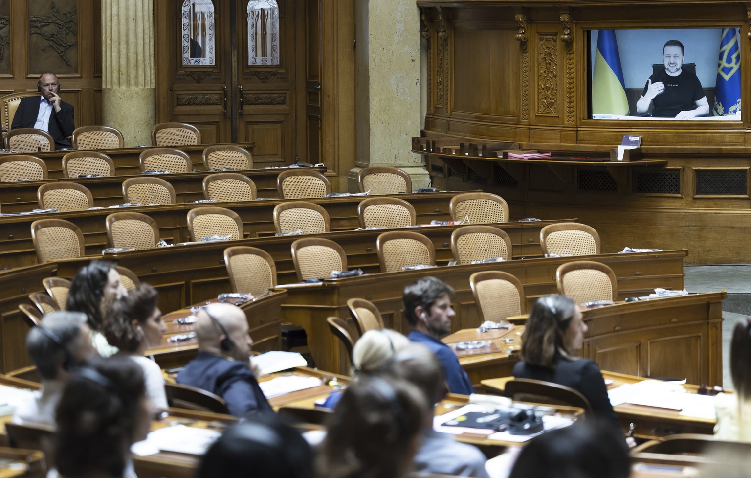 Ukrainian President Volodymyr Zelenskyy is displayed on a screen in front of the empty seats of the members of the right wing party SVP during his speech to the members of the Swiss parliament in Bern ...