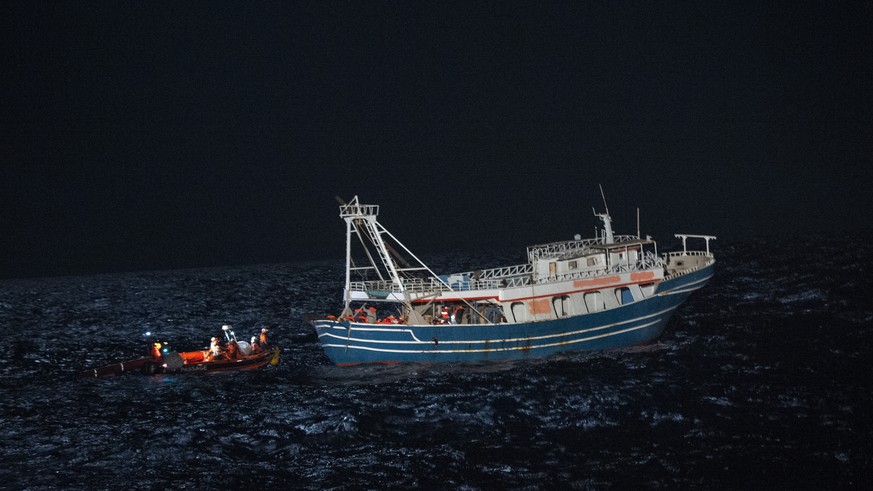 The crew of the rescue boat Geo Barents approach on a dinghy a fishing boat in the international waters off the coast of Libya Tuesday, April 4, 2023. Some 440 refugees from Pakistan, Bangladesh, Egyp ...