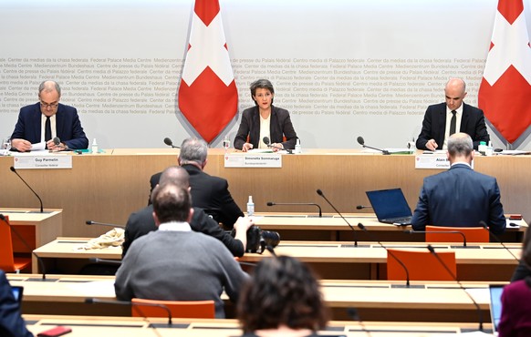 Bundespraesidentin Simonetta Sommaruga, Mitte, spricht an einer Medienkonferenz an der Seite von Bundesrat Guy Parmelin, links, und Bundesrat Alain Berset, rechts, am Freitag, 18. Dezember 2020, im Me ...