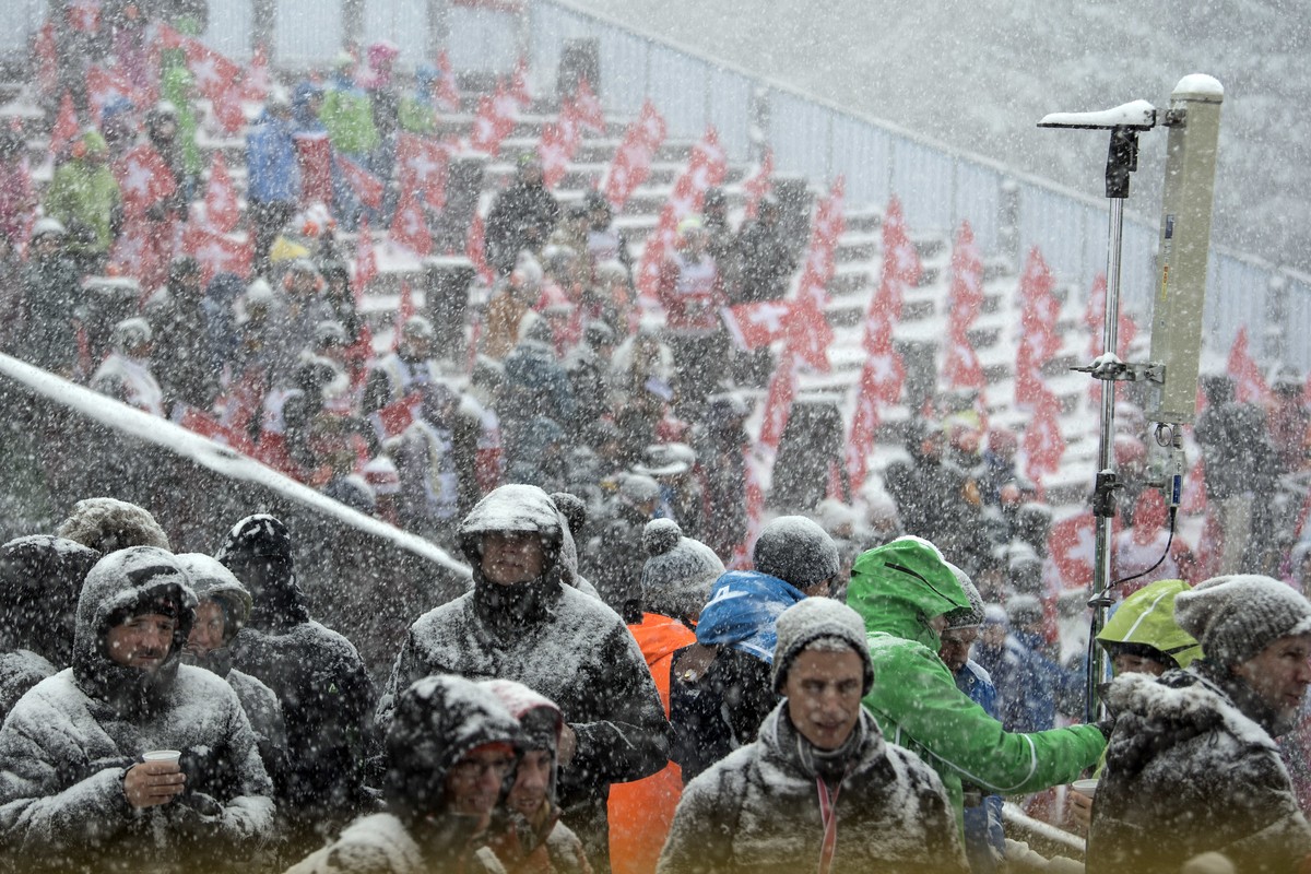 People watch the first run of an alpine ski men's World Cup combined race during heavy snowfall in the finish area in Wengen, Switzerland, Friday, Jan. 13, 2017. (Peter Schneider/Keystone via AP)