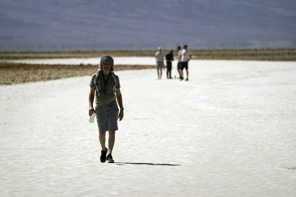People visit visit salt flats in Badwater Basin, Thursday, Sept. 1, 2022, in Death Valley National Park, Death Valley National Park, Calif. (AP Photo/John Locher)