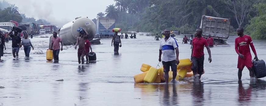FILE- People wade through flooded roads in Bayelsa, Nigeria, Oct. 20, 2022. West and Central African countries are battling deadly floods that have upended lives and livelihoods, raising fears of furt ...