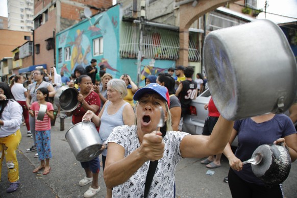 Residents bang pots to protest the day after the presidential election in Caracas, Venezuela, Monday, July 29, 2024. (AP Photo/Cristian Hernandez)