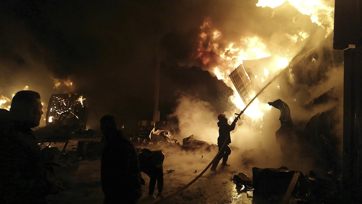 In this photo released by the Syrian official news agency SANA, firefighters work at the scene of missiles attack, at the seaport of the coastal city of Latakia, Syria, Tuesday, Dec. 28, 2021. Israeli ...