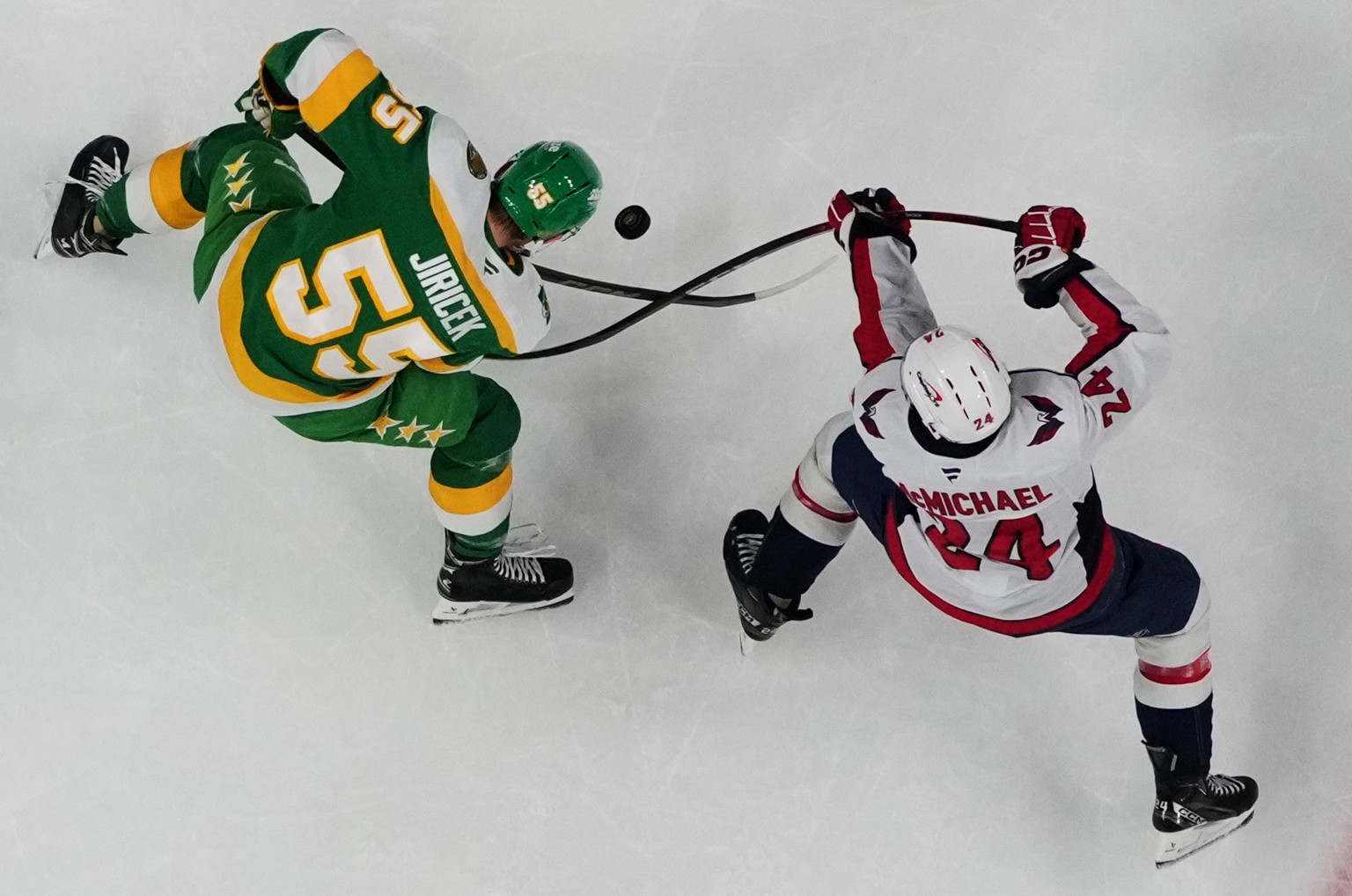 Minnesota Wild defenseman David Jiricek (55) and Washington Capitals center Connor McMichael (24) battle for the puck during the first period of an NHL hockey game, Tuesday, Dec. 16, 2025, in St. Paul ...