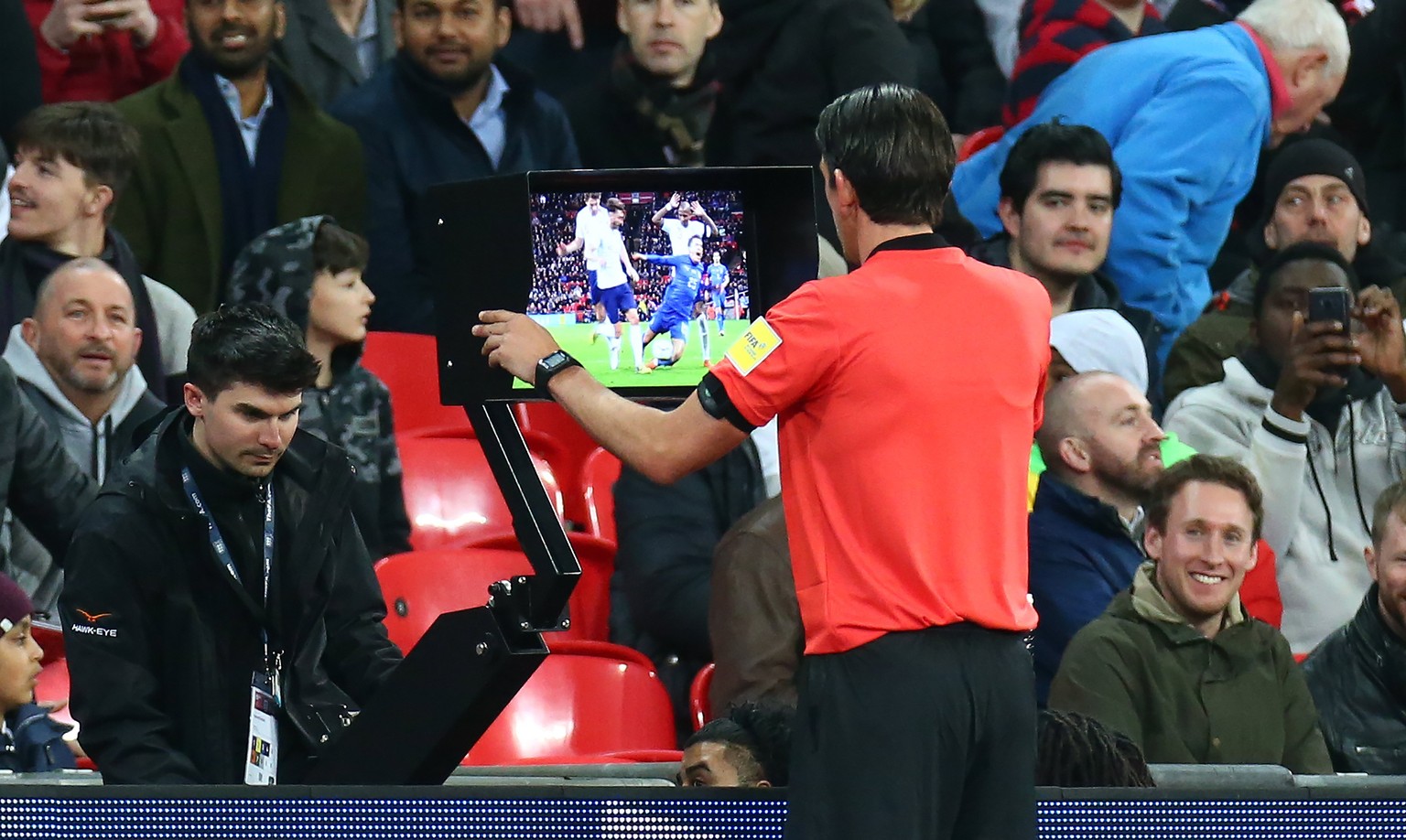 epa06633192 Referee Deniz Aytekin of Germany looking at the VAR during the International friendly match between England and Italy at the Wembley Stadium in London, Britain, 27 March 2018. EPA/KIERAN G ...