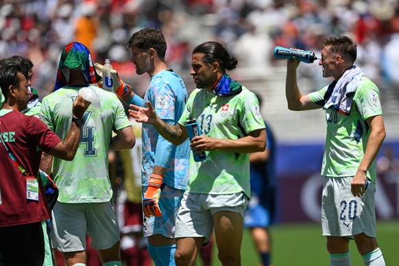 Switzerland's Michel Aebischer squirts water onto his face as the players take a mandatory hydration break during the World Cup Group B soccer match between Qatar and Switzerland in Santa Clara,  ...