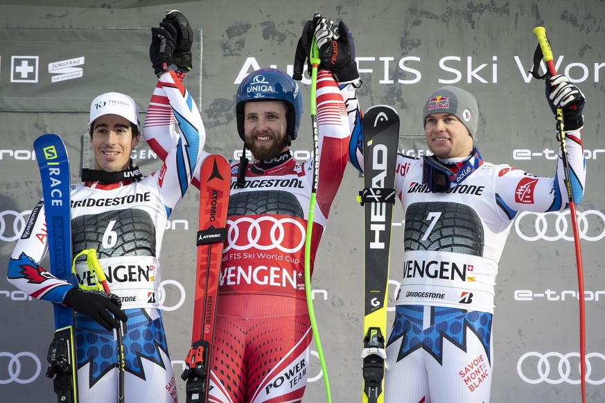 epa07297055 (L-R) Victor Muffat-Jeandet of France, second place, Marco Schwarz of Austria, winner, and Alexis Pinturault of France, third place, celebrate in the finish area during the flower ceremony ...