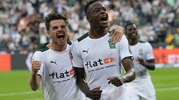 Moenchengladbach's scorer Denis Zakaria, right, celebrates with Moenchengladbach's Jonas Hofmann, left, after he scored the opening goal during the German Bundesliga soccer match between Borussia Moenchengladbach and Borussia Dortmund in Moenchengladbach, Germany, Saturday, Sept. 25, 2021. (AP Photo/Martin Meissner)