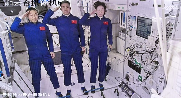 In this screen image captured at Beijing Aerospace Control Center released by Xinhua News Agency, Chinese astronauts from left, Liu Yang, Chen Dong and Cai Xuzhe salute after entering the space statio ...
