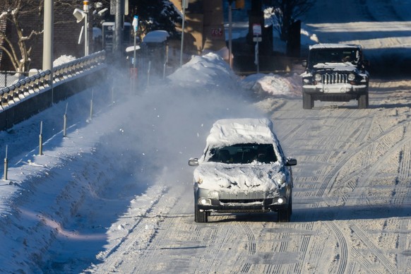 Snow blows off of a vehicle as it is driven along Fulton Street in Grand Rapids, Mich. on Friday, Jan. 23, 2026. (Joel Bissell/Kalamazoo Gazette via AP)