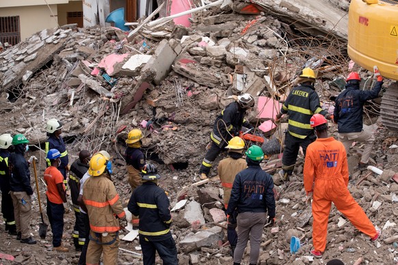 epa09418290 Rescuers work in search and rescue of victims and survivors of the earthquake that shook the country 14 August, in Les Cayes, Haiti, 17 August 2021. The United Nations has allocated eight  ...