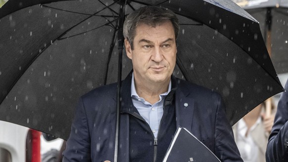 Markus Söder (CSU), Prime Minister of Bavaria and CSU chairman, arrives under an umbrella for exploratory talks between the CDU and B