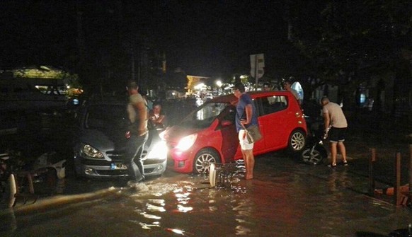 People try to move the cars from a flooded coastal road after an earthquake on the Greek island of Kos early Friday, July 21, 2017. A powerful earthquake struck Greek islands and Turkey&#039;s Aegean  ...