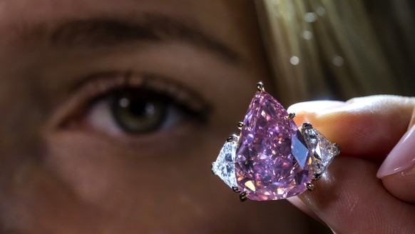 A Christie&#039;s employee displays a fancy vivid pink modified pear brilliant-cut diamond called &quot;The Fortune Pink&quot; of 18,18 carat, during a preview at the Christie&#039;s, in Geneva, Switz ...