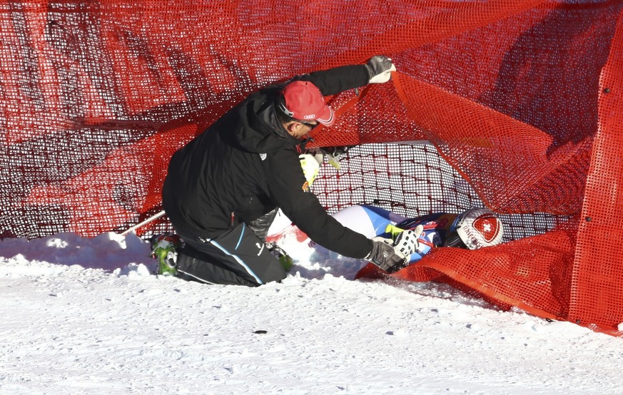 Switzerland&#039;s Beat Feuz, right, gets assistance after crashing during an alpine ski, men&#039;s World Cup downhill, in Kitzbuehel, Austria, Saturday, Jan. 21, 2017. (AP Photo/Alessandro Trovati)