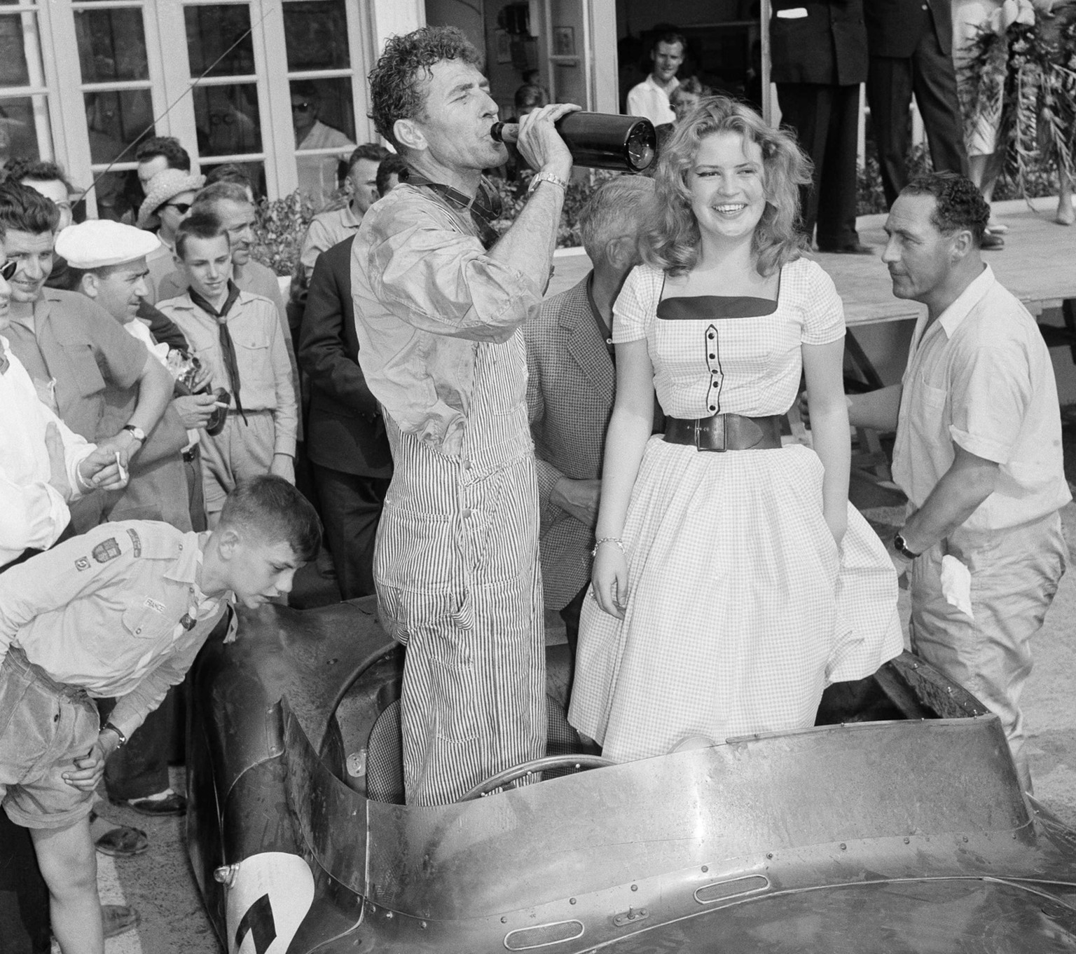 Texas driver Carroll Shelby enjoys swig of champagne after combining with British veteran Roy Salvadori to win the 24-Hour Endurance Auto Classic at Le Mans, France, on June 21, 1959. Dressing up the  ...