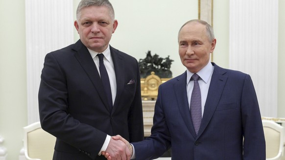 Russian President Vladimir Putin, right, and Slovak Prime Minister Robert Fico shake hands during their meeting at the Kremlin in Moscow, Russia, Sunday, Dec. 22, 2024. (Gavriil Grigorov, Sputnik, Kre ...