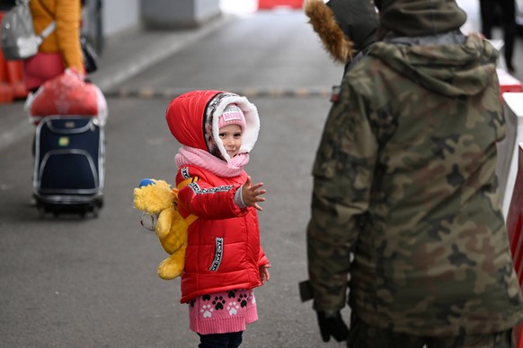 epa09872517 A Polish soldier assists war refugees from Ukraine at the Polish-Ukrainian border crossing in Korczowa in south-eastern Poland, 05 April 2022. Russian troops entered Ukraine on 24 February ...