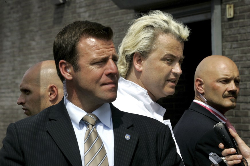 in this May 26, 2005 file photo Geert Wilders, second right, is surrounded by security agents in IJmuiden, Netherlands. Wilders said Thursday Feb. 23, 2017, that he will suspend his election campaigni ...